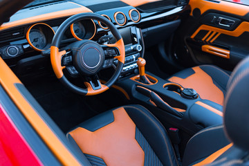 Sports car interior with orange accents.