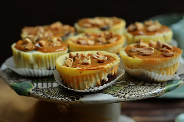 Cheesecake muffins with caramel on a rustic plateau