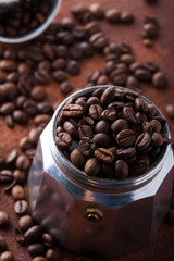 Fototapeta premium Photo closeup of coffee beans in Aluminium Espresso Coffee Maker. Rusty background. Copy space.