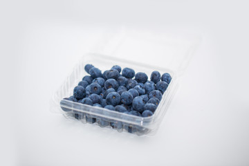 Fresh blueberries in the container isolated on white background.