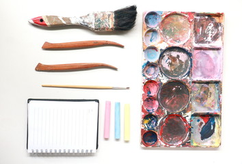 paint brushes, Palette ,notebook on a colorful painter in white black ground. 