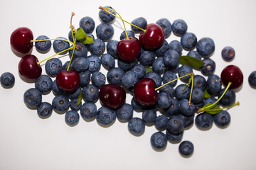 Ripe tasty cherry and blueberry on white background, top view