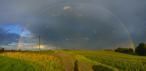 double rainbow in the evening sky above a dirt road in Germany, Panorama