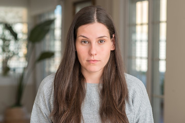 Obraz premium Young beautiful woman at home with serious expression on face. Simple and natural looking at the camera.
