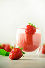 Healthy strawberry smoothie in glass on gray background with copy space. Banner. Summer food and clean eating concept, vegan diet. Pink detox beverage with fresh berries