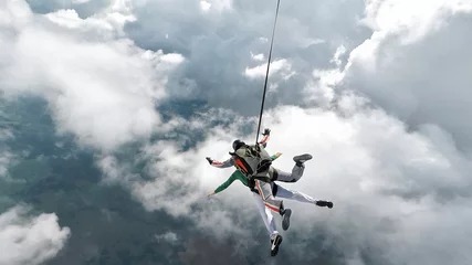 Foto op Plexiglas Luchtsport Parachutespringende tandem die in de wolken valt