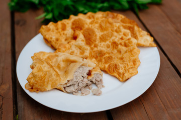 The Caucasian food is a patty made from thin unleavened dough with stuffed lamb and spicy seasonings. Cheburek - fried pie with meat and onions. Traditional dish of many tatar and eastern peoples.