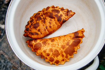 The process of cooking chebureks. The Caucasian and eastern food is a patty made from thin unleavened dough with stuffed lamb and spicy seasonings. Cheburek - fried pie with meat and onions. 