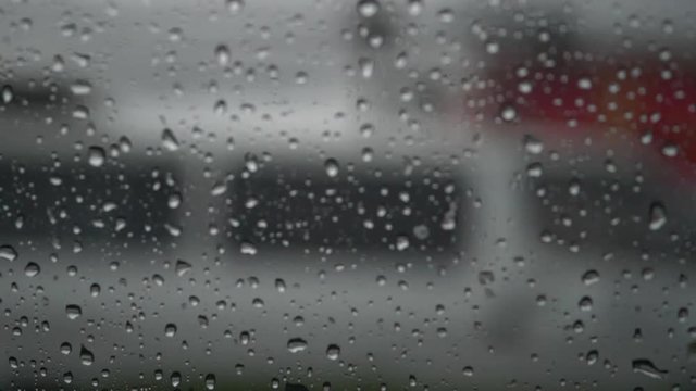 slow motion, rain drops on window car with driving on traffic road