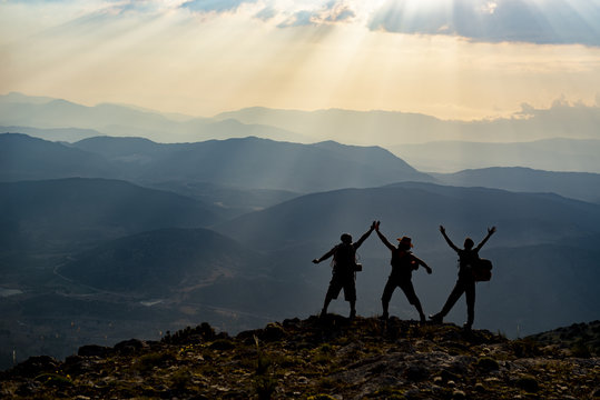 joyful happiness at the peak of three adult men and mountains