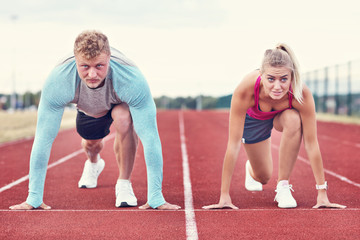 Man and woman racing on outdoor track