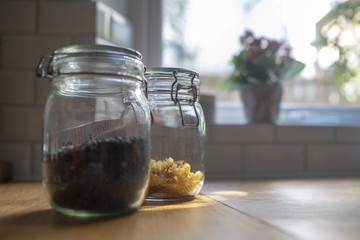 Pasta and lentils in glass jars on wooden table