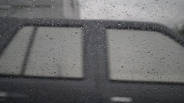 slow motion, rain drops on window car with driving on traffic road
