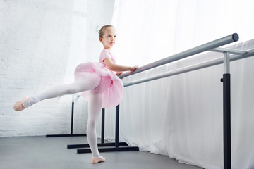 adorable little ballerina in pink tutu practicing in ballet studio © LIGHTFIELD STUDIOS