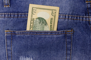 Ten dollars banknote in the pocket of blue jeans