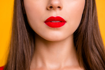 Fototapeta premium Bliska pół twarzy upraw portret kobiety brunetka z czerwonymi ustami lekko otworzył usta na żywym żółtym tle