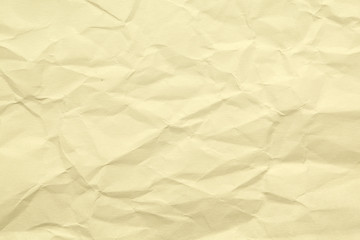 Paper beige color aged and wrinkled. Background of brown color with kinks and fraying.