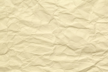 Paper beige color aged and wrinkled. Background of brown color with kinks and fraying.