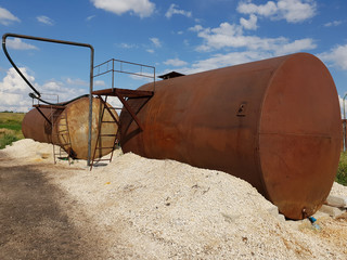 Tanks with liquid fertilizers on outskirts of field.