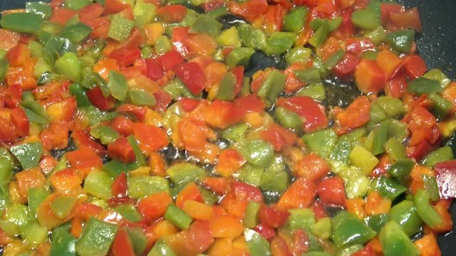 4k, Chef cooking red and green peppers in a frying pan. Roasting stewpan with tasty and healthy vegetables. Different color organic pepper sliced. Delicious nutritious organic dietary -Dan