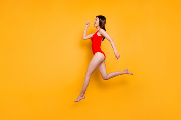 Fototapeta na wymiar People life energy concept. Full-size portrait of fit sporty girl jumping over in the air isolated on yellow background with copy space for text