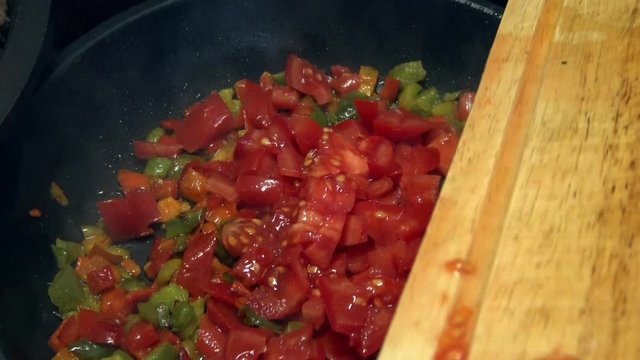 4k, Chef cooking red and green peppers with tomatoes in frying pan. Roasting stewpan with tasty and healthy vegetables. Different color organic pepper sliced. Delicious nutritious organic dietary -Dan