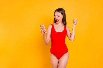 So many likes and subscribers on my page in social network! Pretty cheerful nice glad satisfied lady raising fist up holding smart phone in hand isolated vivid background