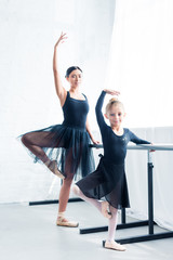 beautiful young ballet teacher and cute little student dancing together in ballet studio © LIGHTFIELD STUDIOS
