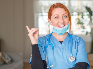 Medical professional woman with stethoscope very happy pointing with hand and finger to the side