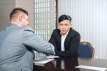 two business partners sitting at a table together and working.