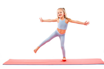 Kid girl doing fitness or yoga exercises isolated on white background. Sport concept.