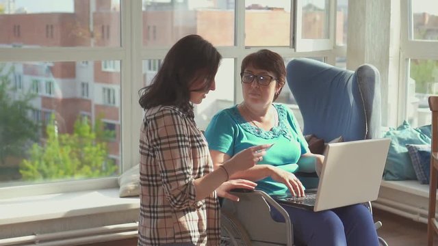 Woman in a wheelchair working with a female colleague