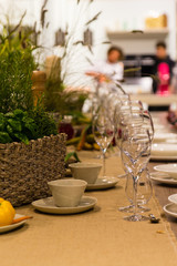 Empty wine glasses, cups and basket with greenery
