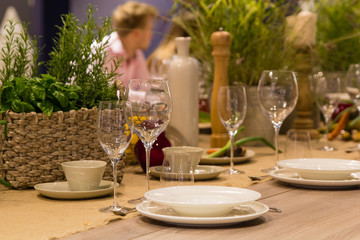 Empty wine glasses, cups and basket with greenery