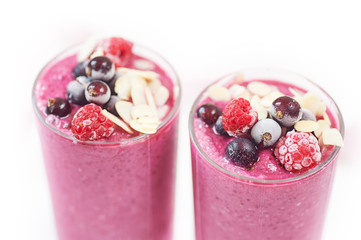 Two glasses of pink fruit smoothies milkshake or smoothie or cocktail on a white wooden background. Healthy juicy vitamin drink diet or vegan raw food concept