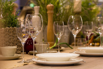 Empty wine glasses, cups and basket with greenery