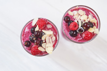Two glasses of pink fruit smoothies milkshake or smoothie or cocktail on a white wooden background. Healthy juicy vitamin drink diet or vegan raw food concept