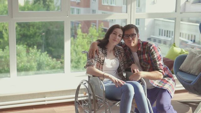 Family couple disabled girl and her husband look at the camera