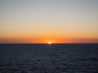 Orange sun setting over sea