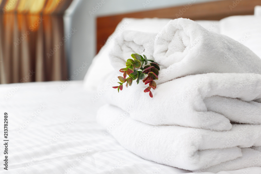 Sticker towels and flower on bed in hotel room