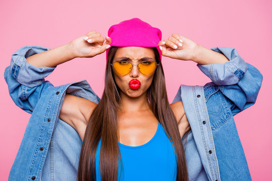 I'm offended by you! Don't talk to me! We aren't friend anymore! Close up photo portrait of sad unhappy attractive girl wearing yellow transparent glasses touching hat isolated bright background