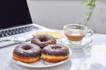 the break in the office . doughnut on laptop keyboard