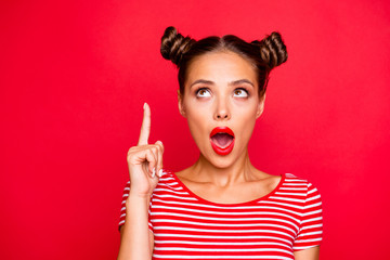 OMG! Close up face of attractive astonished brunette girl with modern hairdo having wide open mouth and brown eyes looking up and show isolated fingers up on red background with copy space