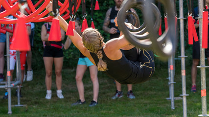 Female athlete climbing on rigs at an obstacle course race