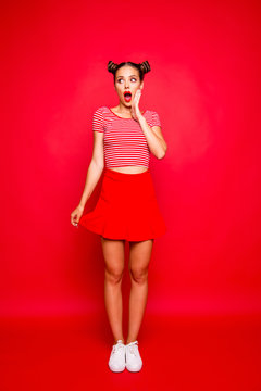 Full-length body vertical portrait of crazy lovely joyful girl with open red mouth, shocked by great news isolated on red background