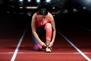 Athlete girl trying running shoes getting ready for race on track