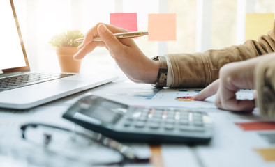 Close up Businessman and partner using calculator and laptop for calaulating finance, tax,...