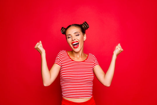 Portrait of cheerful girl with toothy smile raised hands and showing successful celebrate goal isolated on red background