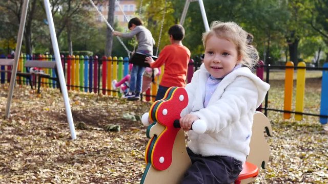Kid girl sway play on an outdoors park playground for children