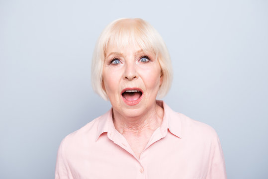 Old lady amazed shocked wow facial expression on grey background